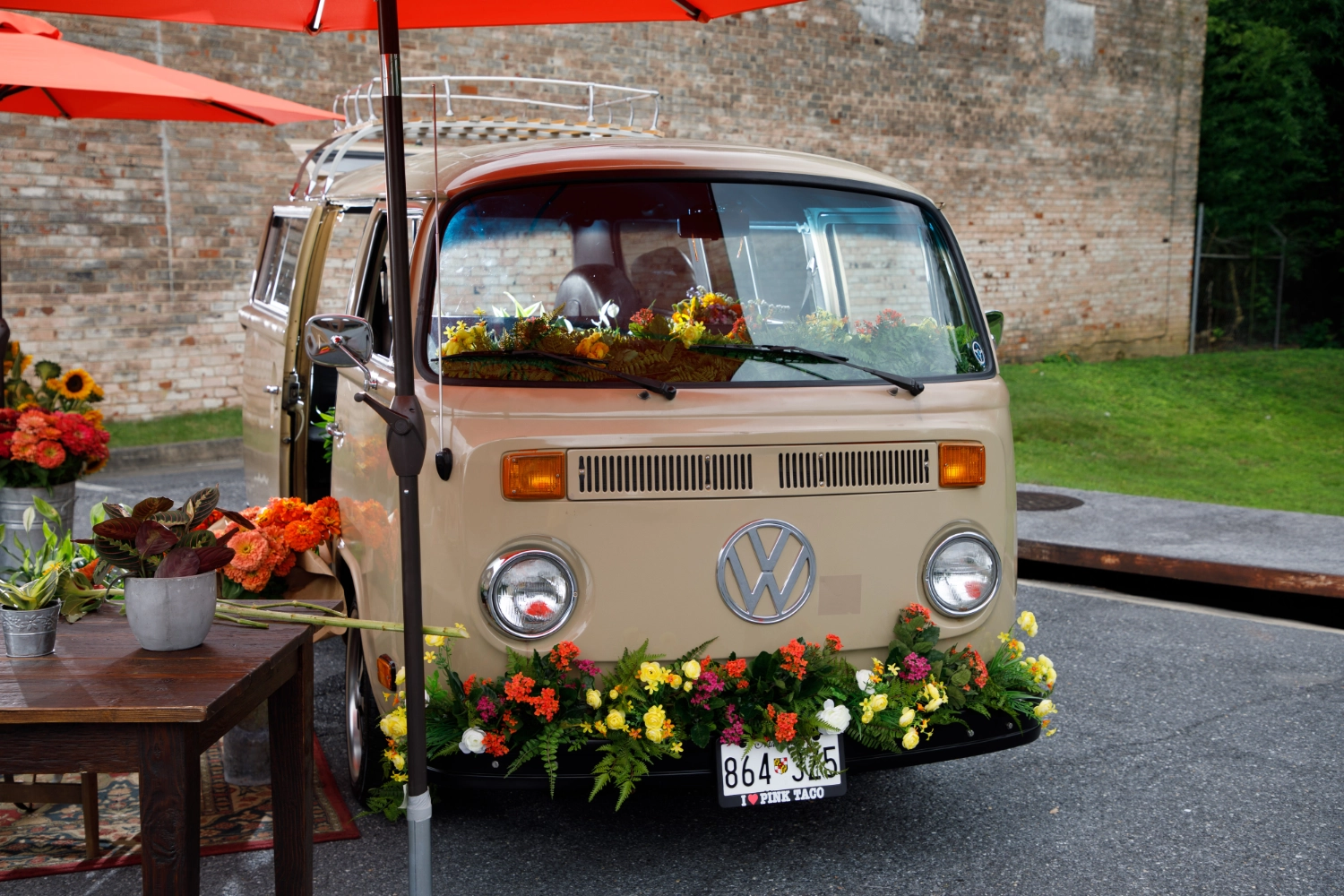 The front of the VW Blooming Bus dressed with a garland of fresh flowers for an event
